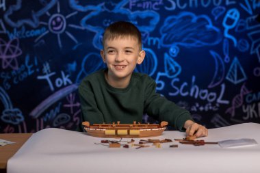 Eğlenceli bir eğitim aktivitesinden hoşlanan bir çocuk, dinamik bir sınıf ortamında bir gemi modeli inşa ediyor. Genç yaratıcılığa ve öğrenmeye ilham veriyor..