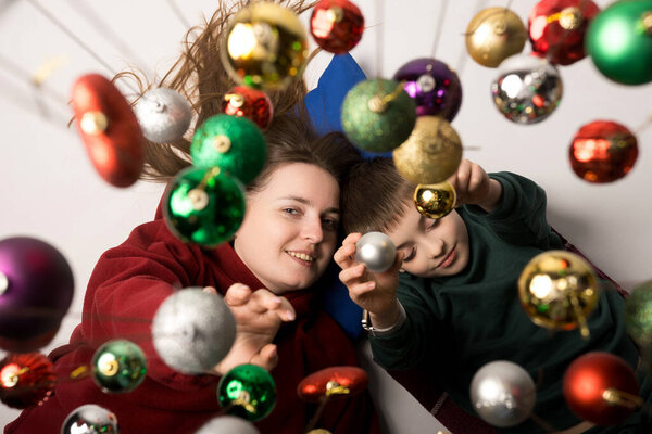Smiling mother and her child enjoying Christmas time, framed by sparkling holiday decorations. Perfect for family, love, and celebration themes.