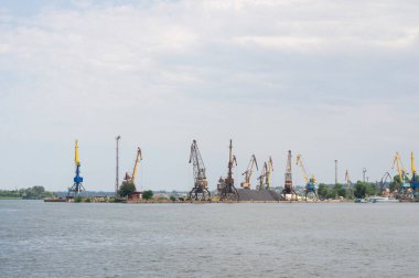 Nehir kenarındaki vinçlerin yükleyip boşalttığı sanayi limanı modern bir nakliye merkezinin hareketli faaliyetlerini ve altyapısını gözler önüne seriyor..