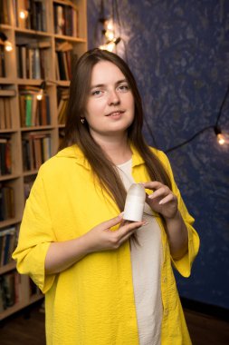 Minimalist beyaz deodorant kutusunu sunan eller. Doğal ve organik kişisel bakım kavramlarına odaklanmış..