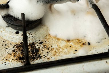 Köpük temizleme köpüğüyle kaplı yağlı ocağı olan kirli bir ocak. Ev işlerinin gerçekçi bir tasviri, mutfak temizliği ve sert lekeleri kaldırma mücadelesi.