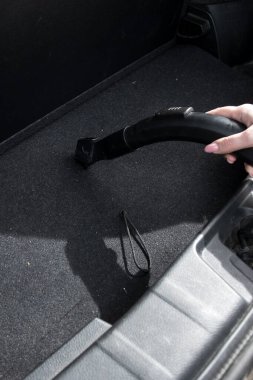 Bir el, arabanın içindeki paspası temizliğe odaklanarak temizler. Araba temizleme ipuçları, araç bakımı ve ev bakımı fikirleri için ideal.