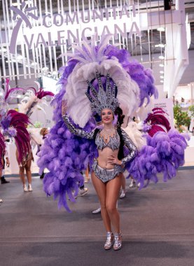 25 Ocak 2025; Madrid; İspanya: FITUR 2025 turizm fuarında abartılı tüylü kostümlü canlı karnaval dansçıları.