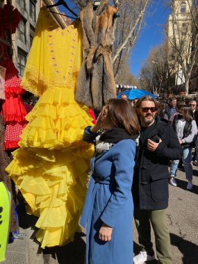 19.03.2023 Madrid İspanya El Rastro Bit Pazarı Geleneksel sarı flamenko elbise pazarda satışta.