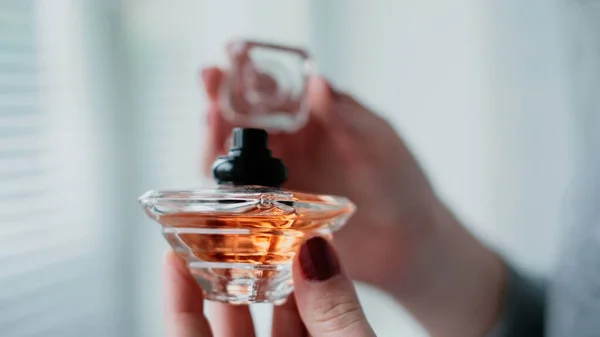 Butelka Perfum Kobiecej Dłoni Tle Wnętrza Jasnego Pokoju Eau Toilette — Zdjęcie stockowe