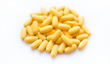 Beyaz arka planda sarı multivitamin haplarının yakın çekim dokusu. Sağlıklı yaşam tarzı kavramı.