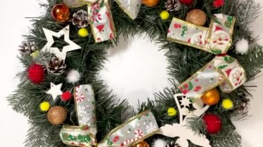 Noel çelengi ladin, gümüş yaylar, yıldızlar ve beyaz arka planda izole edilmiş Noel toplarından oluşan tatiller için ön kapıyı süslüyor..