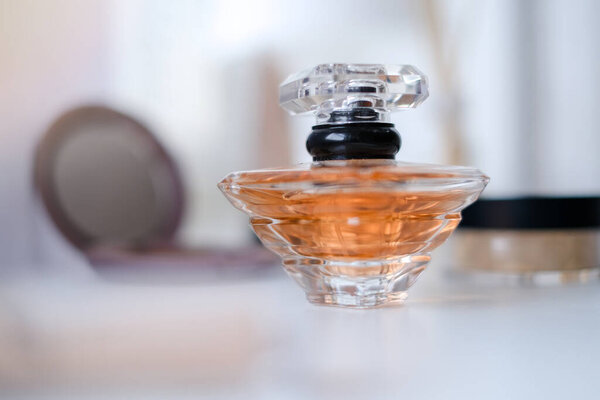 Парфюмерная бутылка в окружении косметики, порошка, лосьона. Eau de tofeltte, eau de parfum, концепция красоты.