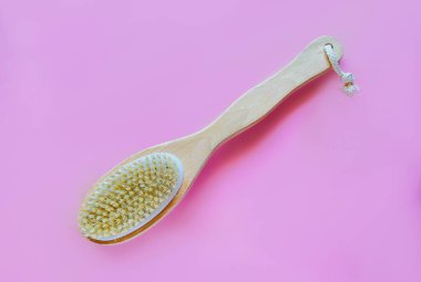 Kuru anti-selülit masajı için kabzalı fırça ya da pembe arka plan fırçası. Güzellik konsepti.