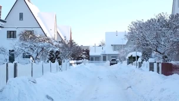 三角形の屋根と多くの雪で覆われた道路の家と通りの冬のおとぎ話の風景 — ストック動画