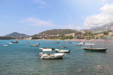 Karadağ 'ın arka planında yüzen tekneleri ve dağları olan deniz manzarası.