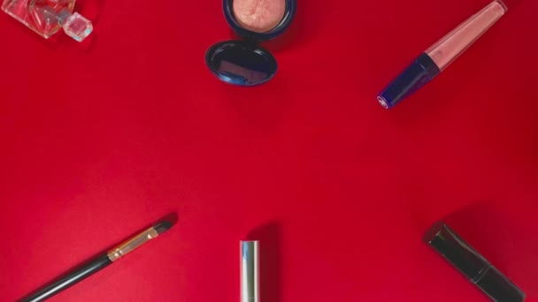 周围点缀有化妆品的唇膏 化妆品刷 睫毛膏和亮红色底色上的口红 — 图库视频影像