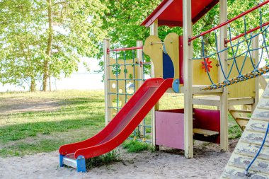 Kırmızı slaytlı çocuk parkı, açık hava eğlencesi için mükemmel..