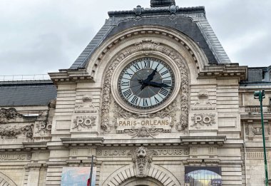 Üzerinde Paris Orleans yazan bir binada büyük bir saat..