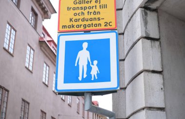 Üzerinde bir adam ve çocuğun yürüdüğü bir tabela. İşaret mavi ve beyaz..
