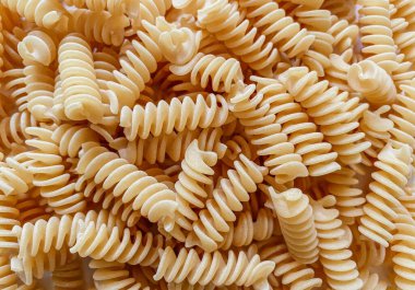 Makro fusilli makarna ve simgesel spiral şekli. Altın desenli makarna İtalyan mutfağı, yemek fotoğrafçılığı ve mutfak geçmişi için mükemmeldir..