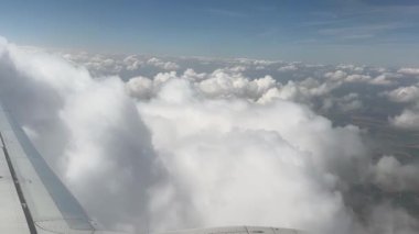 Gökyüzü bulutlarla dolu ve güneş onların arasından parlıyor. Bulutlar beyaz ve yumuşaktır. Huzurlu ve huzurlu bir atmosfer yaratırlar.