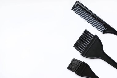 Düz siyah saç fırçaları ve beyaz arka planda bir tarak. Güzelce düzenlenmiş saç boyama araçları, salonlar, güzellik dersleri ya da saç bakımı konseptleri için ideal..