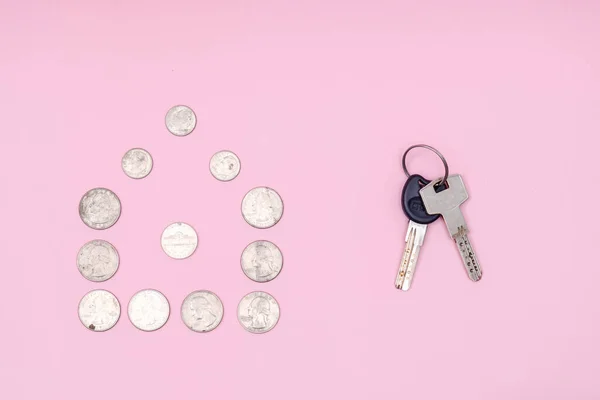 Home keys with coins forming a house