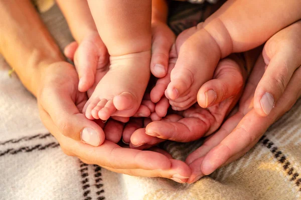 Newborn baby feet in family hands. Symbol of love