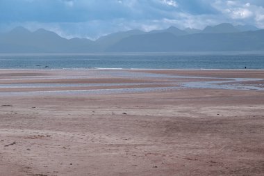 Dalgalar alçaldığında, kırmızı kum plajı, Applecross körfezi. İnsanlar yaz gününde yürür, yüzer..