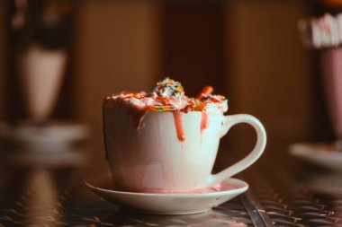 Bir kafede Çilekli Milkshake ve Krema ve Şurup, Sıcak ve Şımarık Bir İçecek Anı Yakalıyor