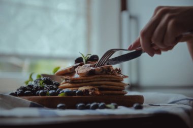 Taze yaban mersini ve nane şekerli ev yapımı krepler, kırsal ve rahat bir ortam için yumuşak sabah ışığında yakalanır.