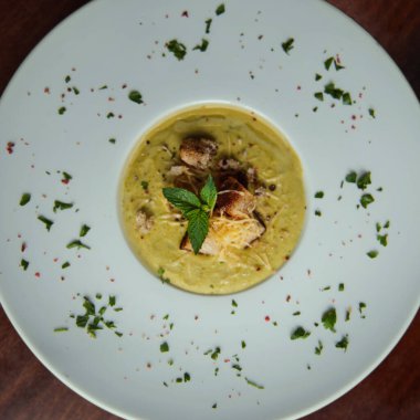 Kremalı avokado çorbası kıtır ekmek, peynir ve nane ile süslenmiş taze ve sağlıklı bir akşam yemeği..