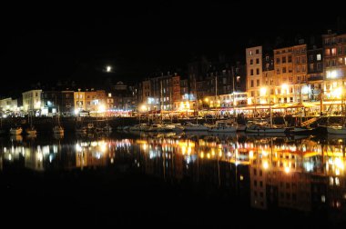 Night Scenery In The Historic Harbour With Brightly Lit Quay Saint-Etienne In Honfleur Normandy France On A Beautiful Summer Evening