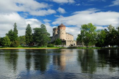 Finlandiya 'da Savonlinna Gölü' nde yansıyan Olavinlinna Şatosu, gökyüzünde birkaç bulutla güneşli güzel bir yaz günüdür.