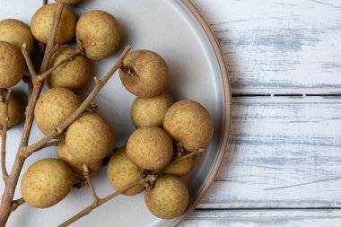 Fotokopi alanı olan bir tabakta bir sürü Longan meyvesi.