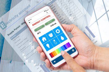 Birisi enerji kullanımını kaydetmek için akıllı telefonda enerji kontrol uygulaması kullanıyor.