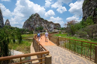 Tourists walk to admire the views of natural attractions along nature trails around beautiful mountains. clipart