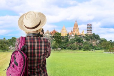Tayland 'ın ünlü turistik yerlerinden biri olan güzel tapınağın fotoğraflarını çeken kadın turistlerin arka plan görüntüsü..