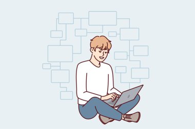 Genç programcı dizüstü bilgisayarla yerde bağdaş kurup web uygulaması yaratıyor. Guy IT geliştiricisi modern web sitesi ya da engelleme projesi üzerinden düşünüyor