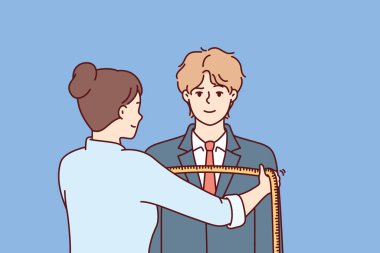 Kadın terzi erkeğin omuzlarını santimetre cinsinden ölçer. Bireysel çizimlere göre terzideki adam el yapımı giysiler yapıyor. 