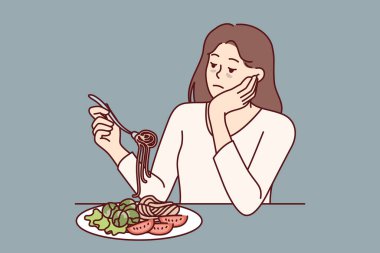İştahsızlık çeken kadın iştahsızlıktan üzgün ve masada spagetti ve salatayla oturuyor. Zayıf görünümlü bir kız yanlış beslenmeden sonra iştahsızlıktan muzdarip.