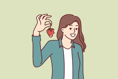 Çilekli bir kadın sağlıklı vitaminler içeren taze organik meyveler yemeyi öneriyor. Güzel bir kızın elindeki büyük çilek iyi meyve hasadı gösteriyor..