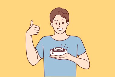 Duman dedektörlü bir adam yangın güvenlik ekipmanı alınmasını tavsiye ediyor. Cihazı test ettikten sonra kaliteli duman dedektörü kullanan genç adam olumlu geri bildirim yapıyor