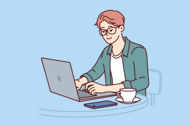Serbest çalışan bir adam, laptopuyla kafede oturup kahve içerek programcı olmanın tadını çıkarıyor. Freelancer çalışanı telefon için taşınabilir bilgisayar ya da mobil uygulama kullanıyor
