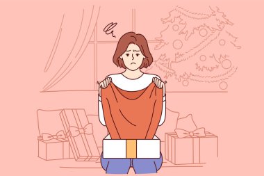 Yılbaşı hediyesine üzülen üzgün kadın, yeni yıl ağacının yanındaki hediye kutularının arasında oturuyor. Kız, Noel tatilinde istenmeyen hediye veya kalitesiz eşya aldıktan sonra stres yaşadı