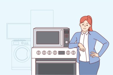 Ev aletleri satan bir kadın fırının ve çamaşır makinesinin yanında durup kameraya bakar. IOT Wi-Fi senkronizasyon teknolojisiyle yeni ev aletleri alırken kız gülümsüyor ve seviniyor
