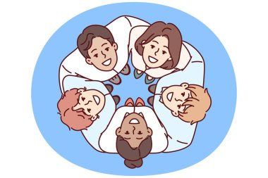 Genç iş adamlarından oluşan bir ekip, ekip oluşturma sırasında çember oluşturup iş arkadaşlarına sarılıyor. Mutlu iş adamları takım çalışmasıyla ya da büyük bir şirketin parçası olmakla gurur duyarlar.