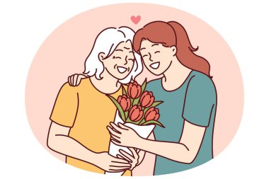 Kadın yaşlı anneye sarılır ve bir buket çiçek verir doğum günüyle ya da anneler günüyle kutlar ve iyi yetiştirildiğiniz için teşekkürler. Yetişkin kız, emeklilik çağının annesine bakıyor.
