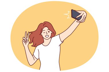 Kadın selfie çekerken gülüyor ve sosyal ağa ya da çöpçatanlık sitesine barış işareti koyuyor. Kız blogcu, aboneler için selfie videosu kaydederek jest yapıyor