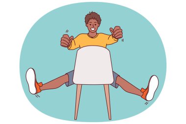 Sandalyede oturan adam elinde görünmez araba direksiyonu tutuyor ve yüksek hızlı yolda taksi şoförü olarak çalıştığını hayal ediyor. Afrikalı Amerikalı genç adam görünmez araba kullanıyor.