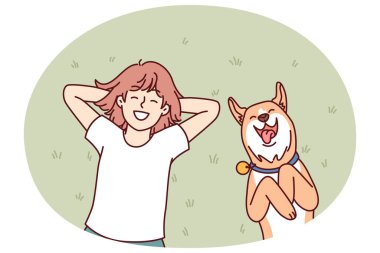 Küçük kız ve köpek evin arka bahçesinde çimlere uzanıp güneşli bir yaz gününün tadını çıkarıyorlar. Kırmızı köpekli gülen genç kız Shiba Inu çimlerde dinleniyor ve tatilin tadını çıkarıyor.