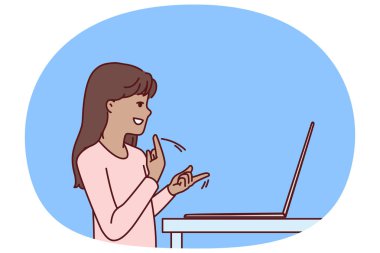 Laptop ve işaret dili kullanan sessiz bir genç kız arkadaşlarına ya da öğretmenine uzaktan eğitim için video çağrısı yapıyor. İletişim kurmayı öğrenirken bilgisayarın yanında duran sessiz çocuk.