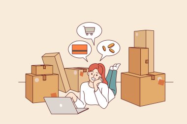 Online mağaza sahibi kadın, karton kutuların arasında dizüstü bilgisayarla yerde yatarak e-ticaretle ilgileniyor. Dijital perakende teknolojileri ve dağıtım hizmetleri sayesinde kız e-ticaretten para kazanıyor.