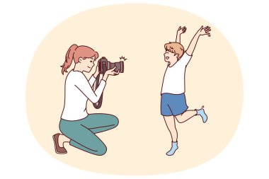 Fotoğrafçı anne ve küçük çocuk çocukluktan mutlu anları yakalamak için profesyonel fotoğraf çekiyorlar. Çocuk mutlu bir şekilde çocuk fotoğrafçısı için poz veriyor. Aile albümü hazırlıyor.